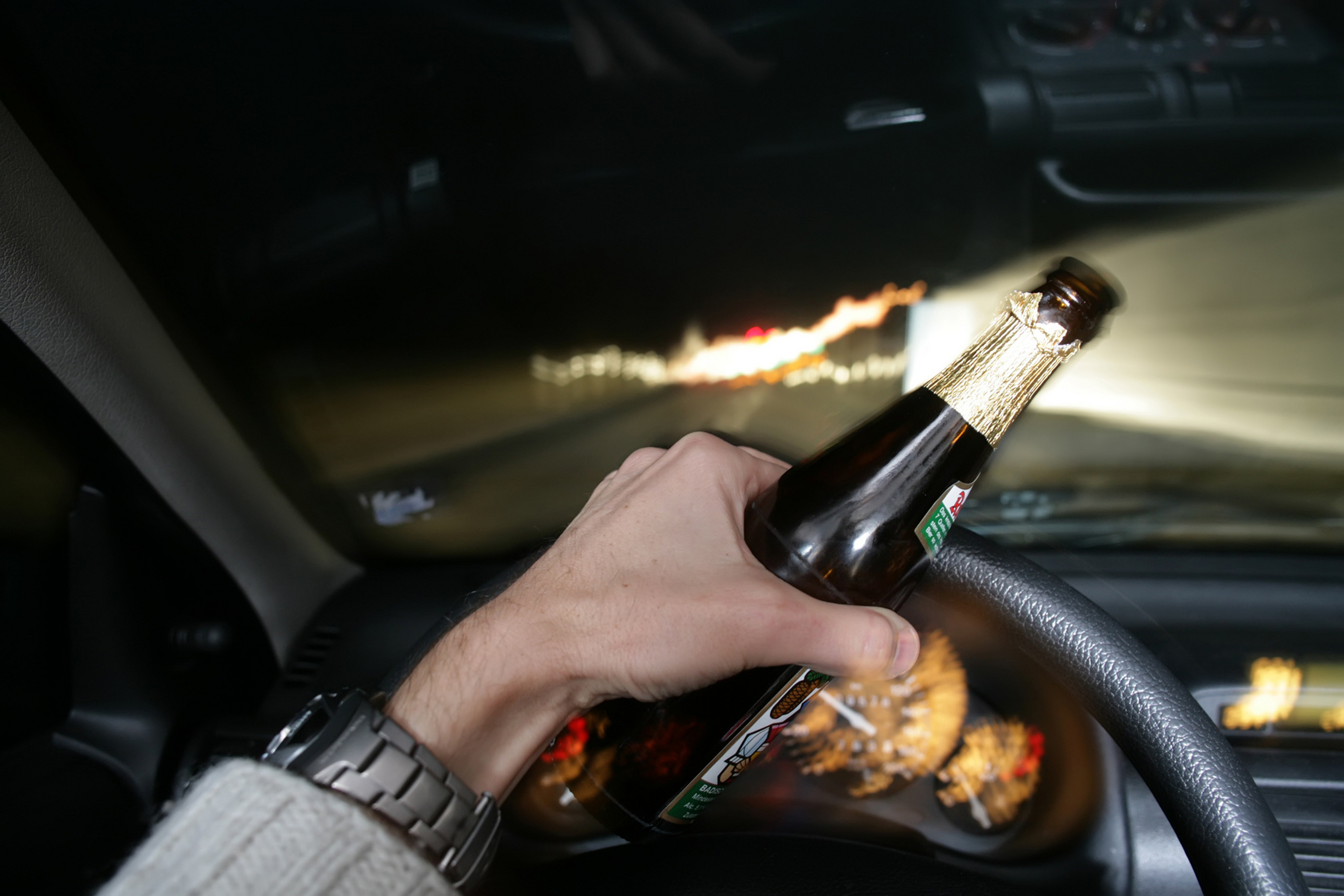 После виски за руль. Алкоголь в машине. Мужчина за рулем с бутылкой. Шампанское в машине.