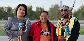 Two Indigenous women holding walks of sorrow